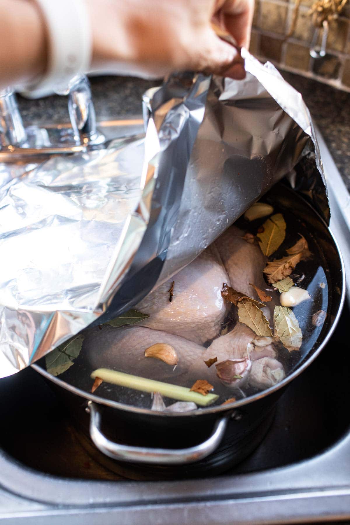 foil over brined turkey in a large container