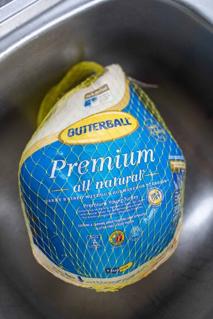butterball turkey in a net in sink.