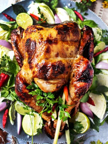 thai roasted turkey on a platter with herbs