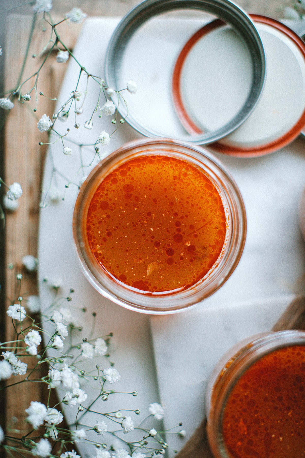 Tom Yum broth in a glass jar over table 