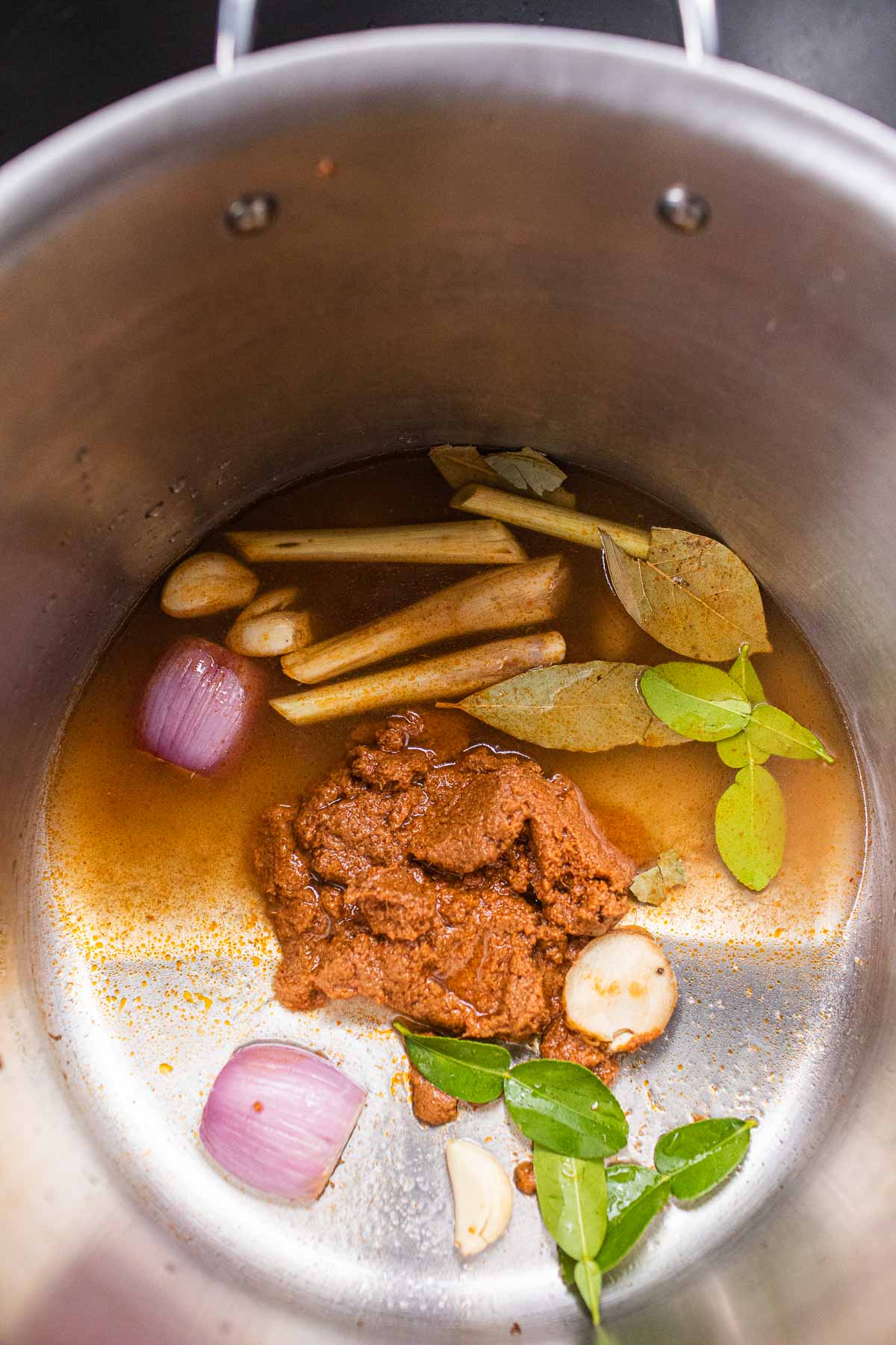 spices and herbs in a stock pot with water for tom yum