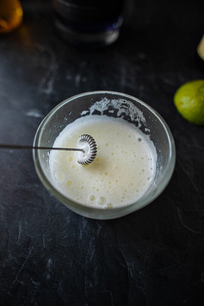 creamy frothing egg white in a glass bowl