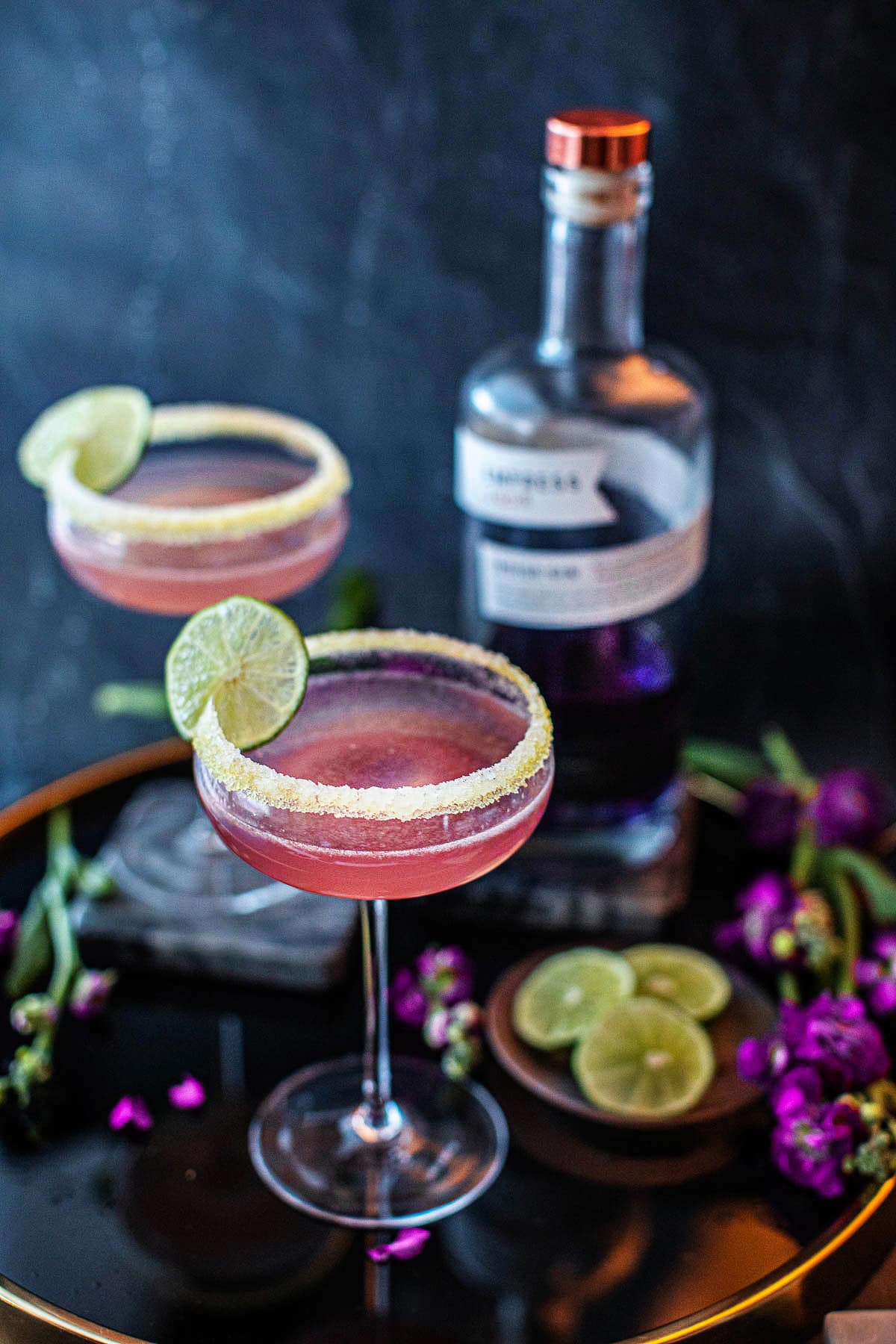 lavender gin cocktail with lime garnish on the table