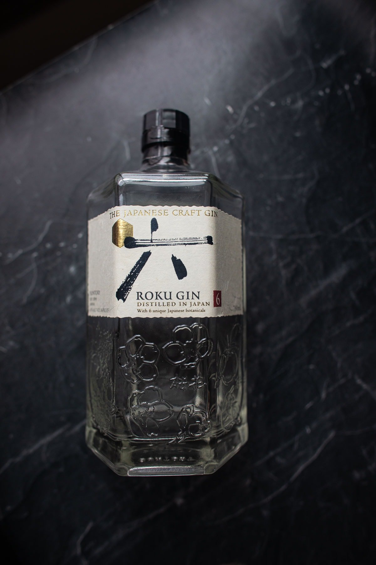 Japanese Roku gin bottle lay flat on a black top