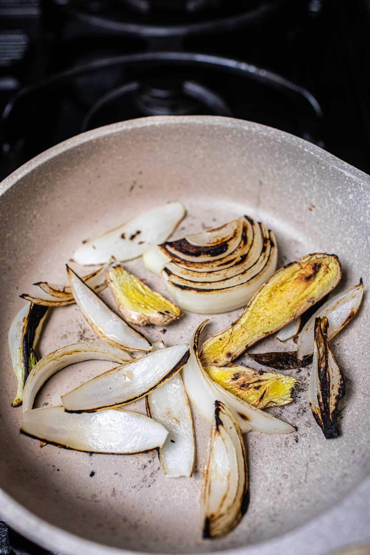 toasted ginge and onion for pho in a pan