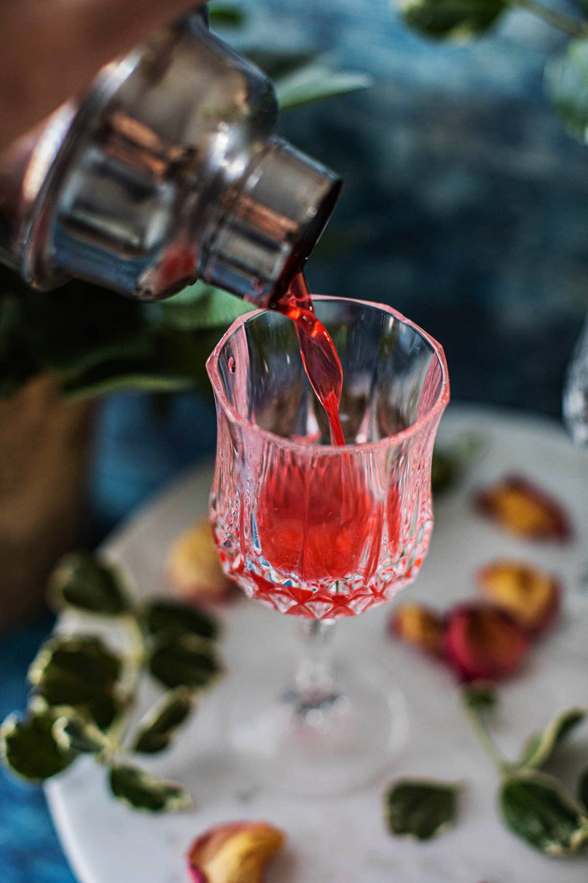 Pouring strawberry gin tonic coctail into a glass 