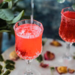 bubbly tonic pouring into a strawberry gin cocktail