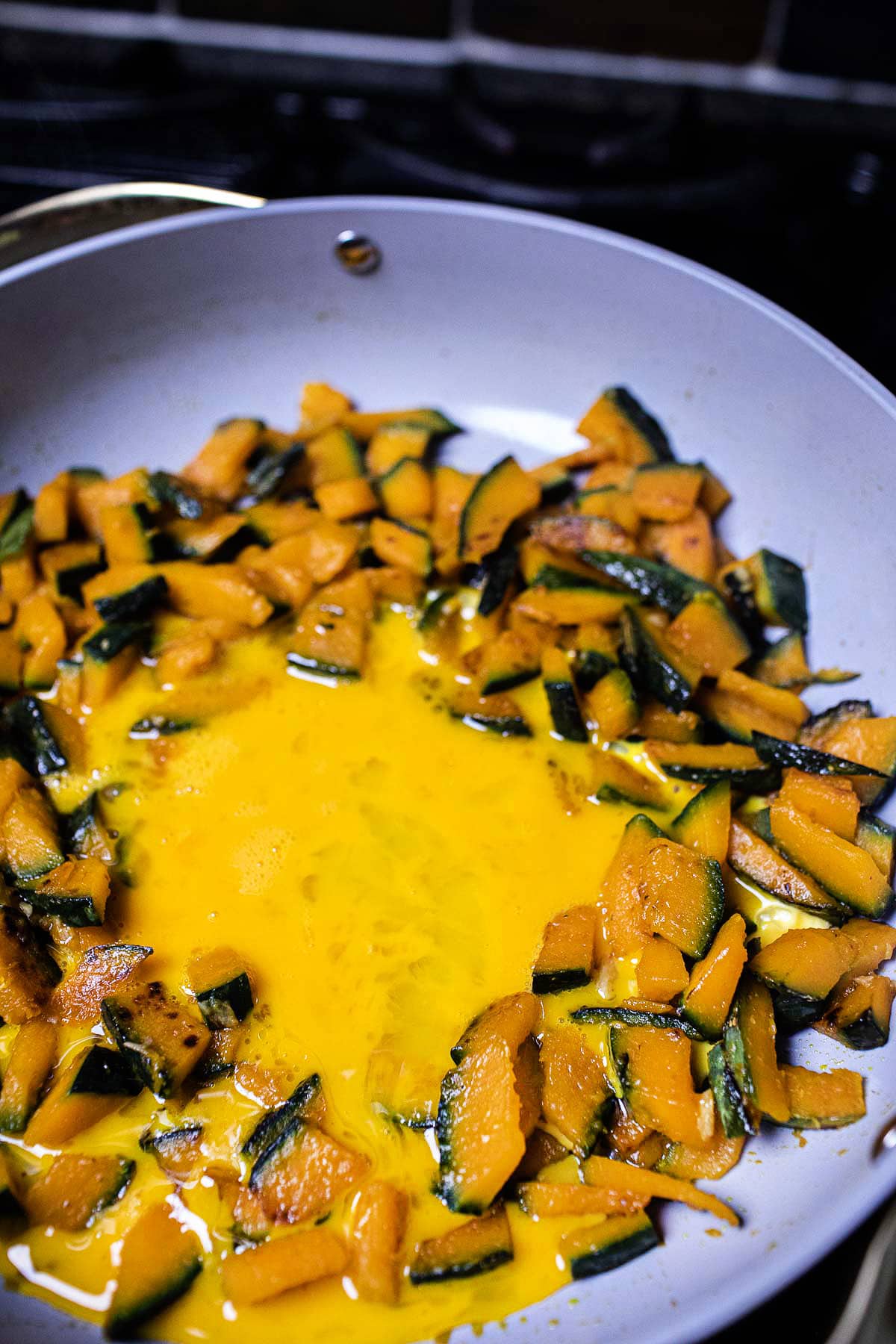 kabocha squash and eggs stir fried in a pan