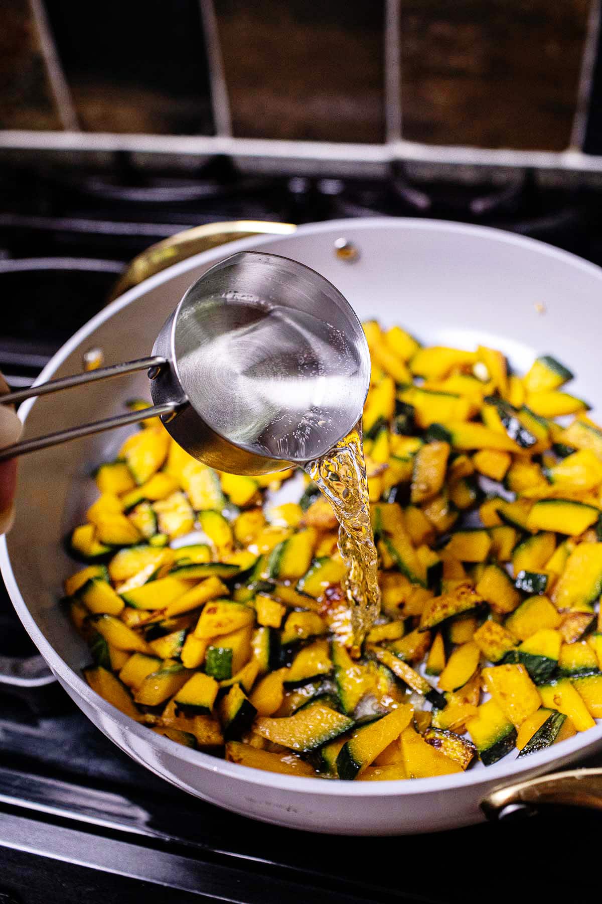 water pouring over pan of kabocha squash