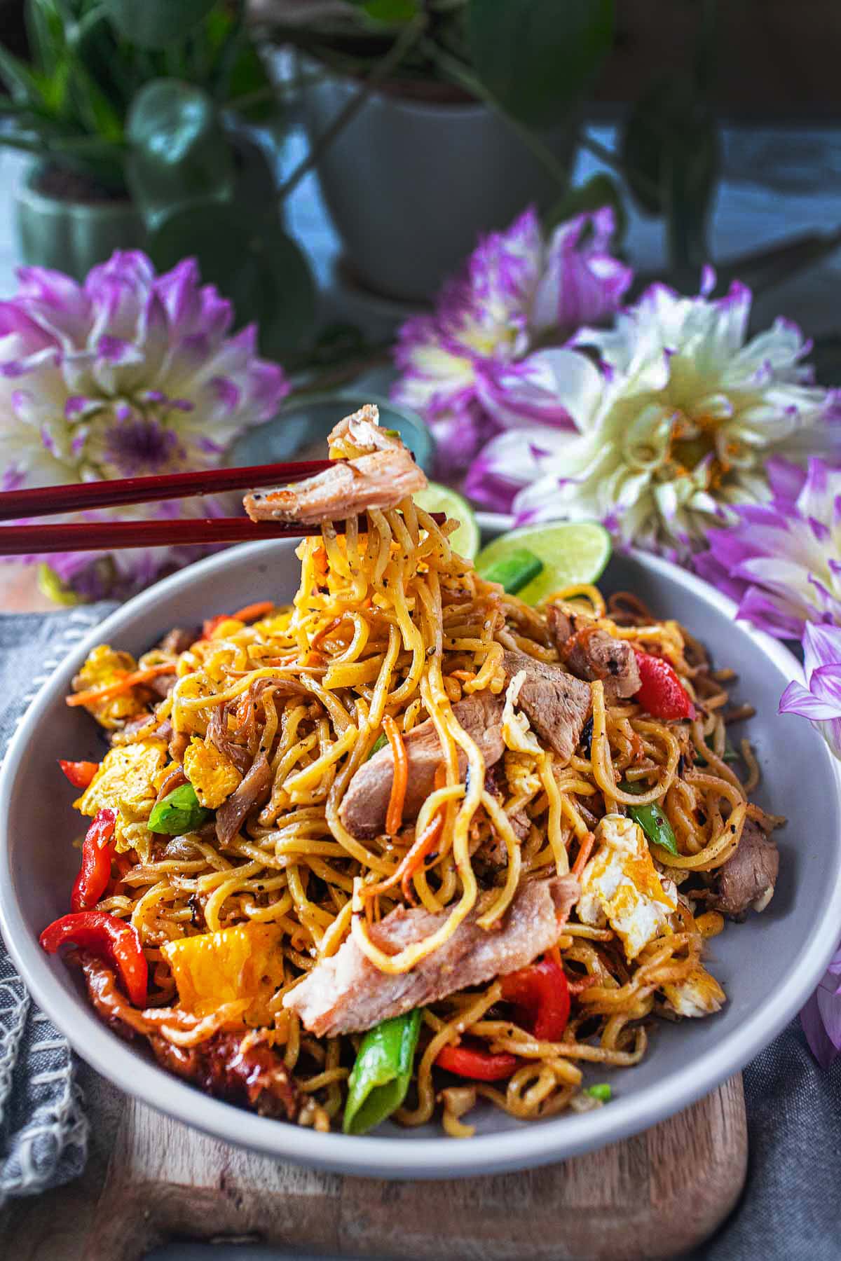 chop sticks lifting yakisoba noodles from a plate