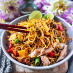 Chop sticks lifting Yakisoba noodle stir fry from a plate