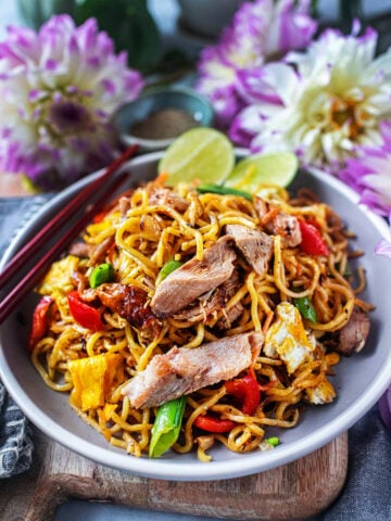 Yakisoba stir fry with turkey with lime wedges garnish