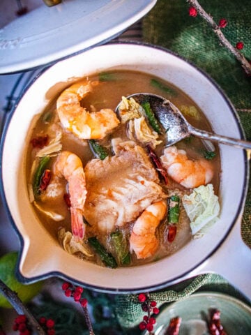 Kaeng som with fish and shrimp in a dutch oven.