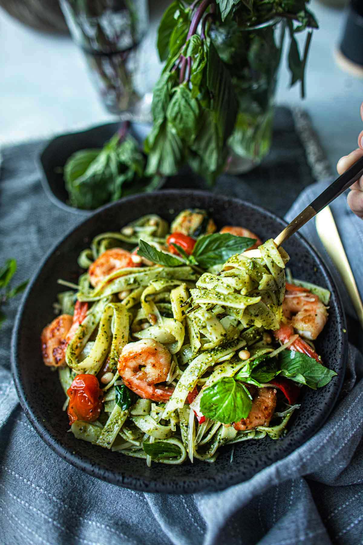 easy thai basil pesto pasta on a plate with a fork lifting noodles