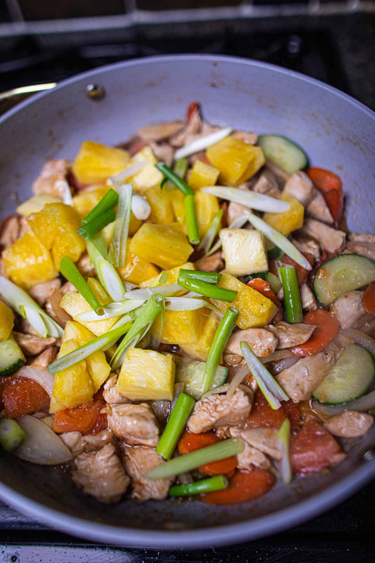 Pineapple stir fry with chicken in a pan.