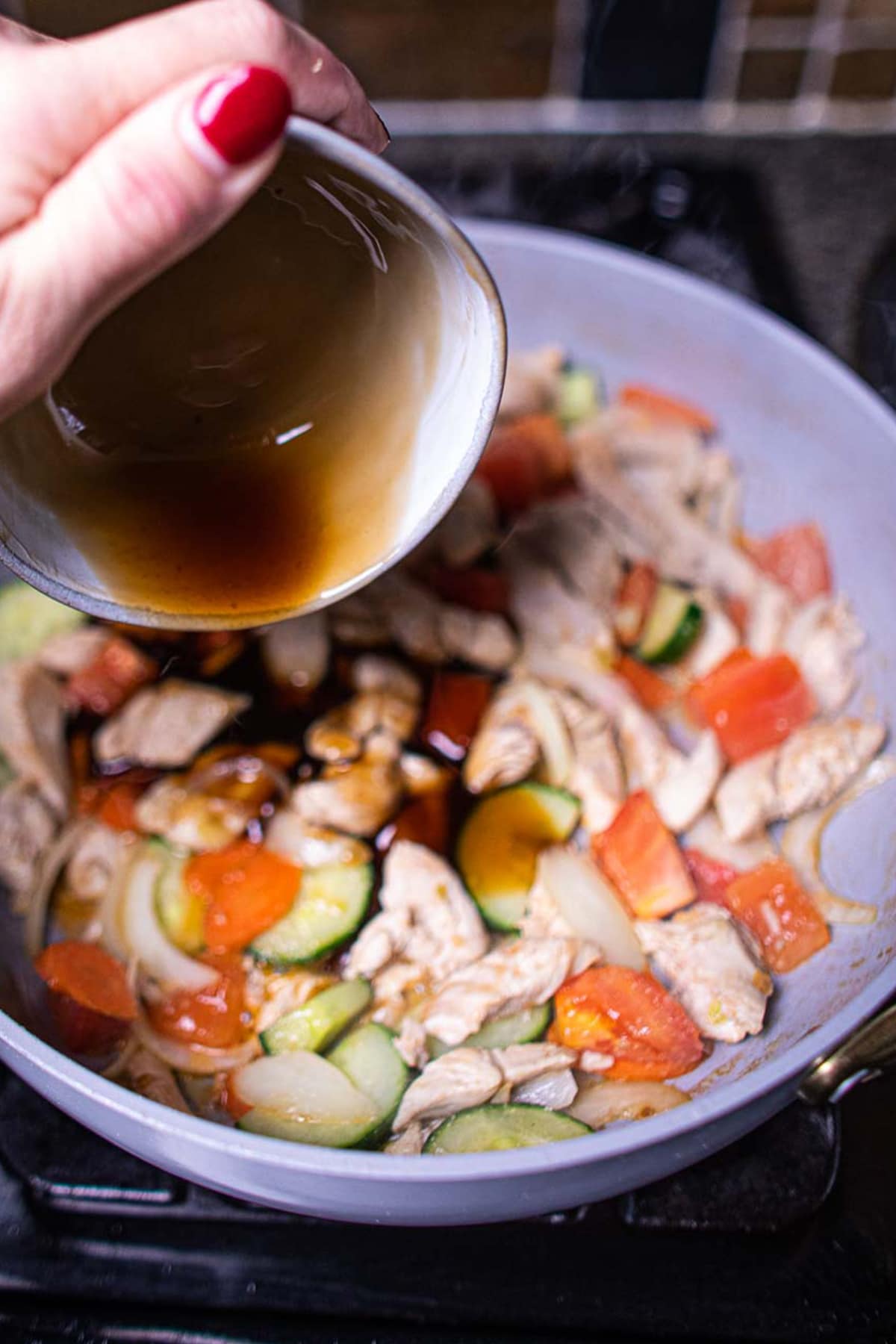 Sauce pouring over pan for sweet and sour stir fry.