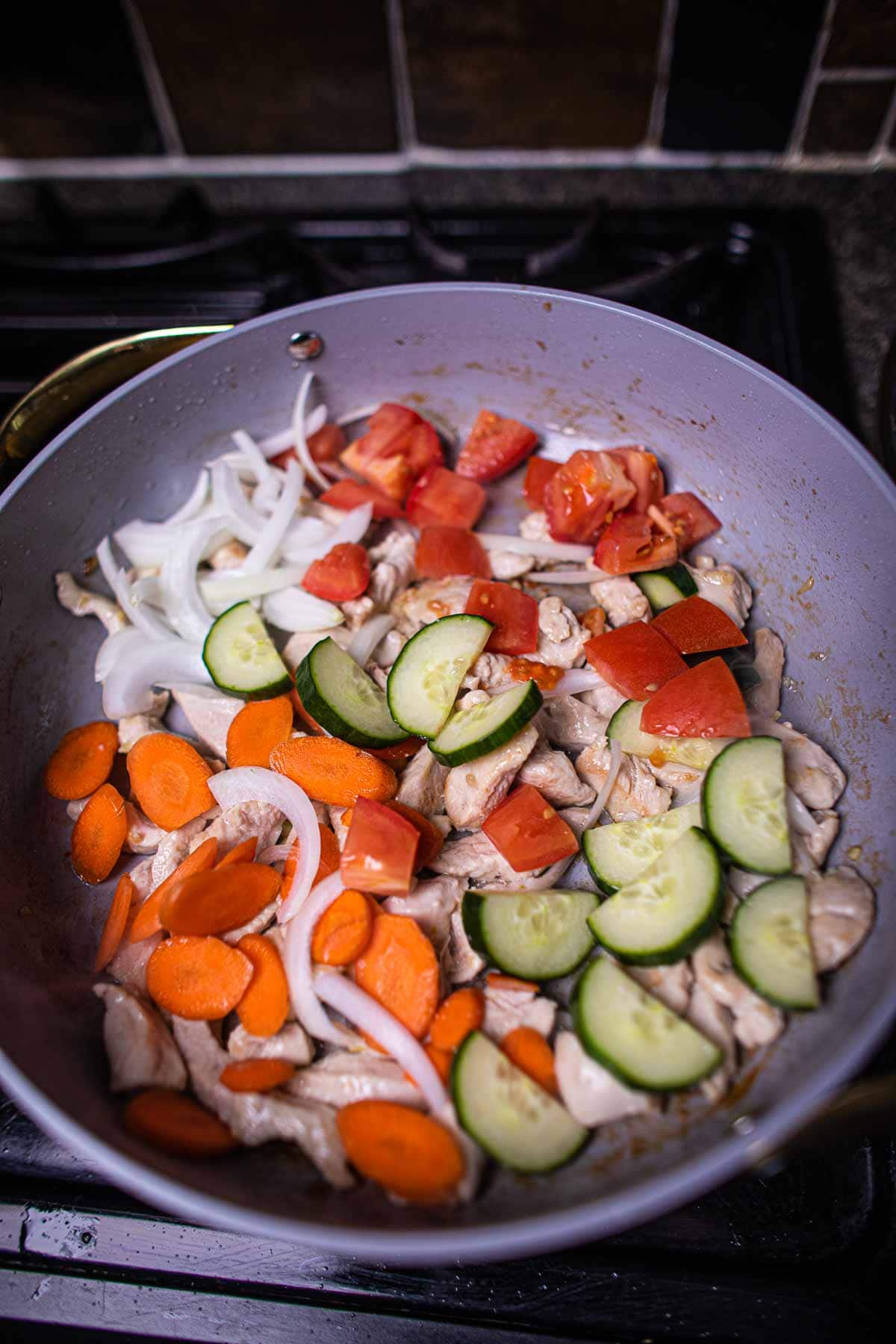 Sweet and sour chicken pineapple stir fry in a pan.