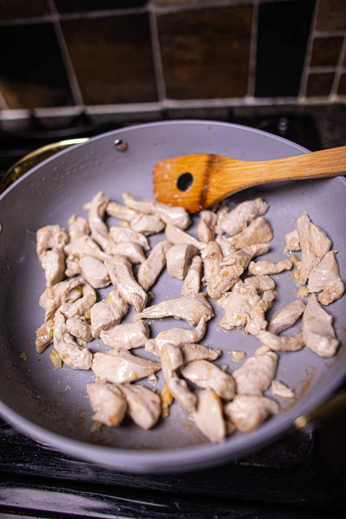 Chicken stir frying in a pan.