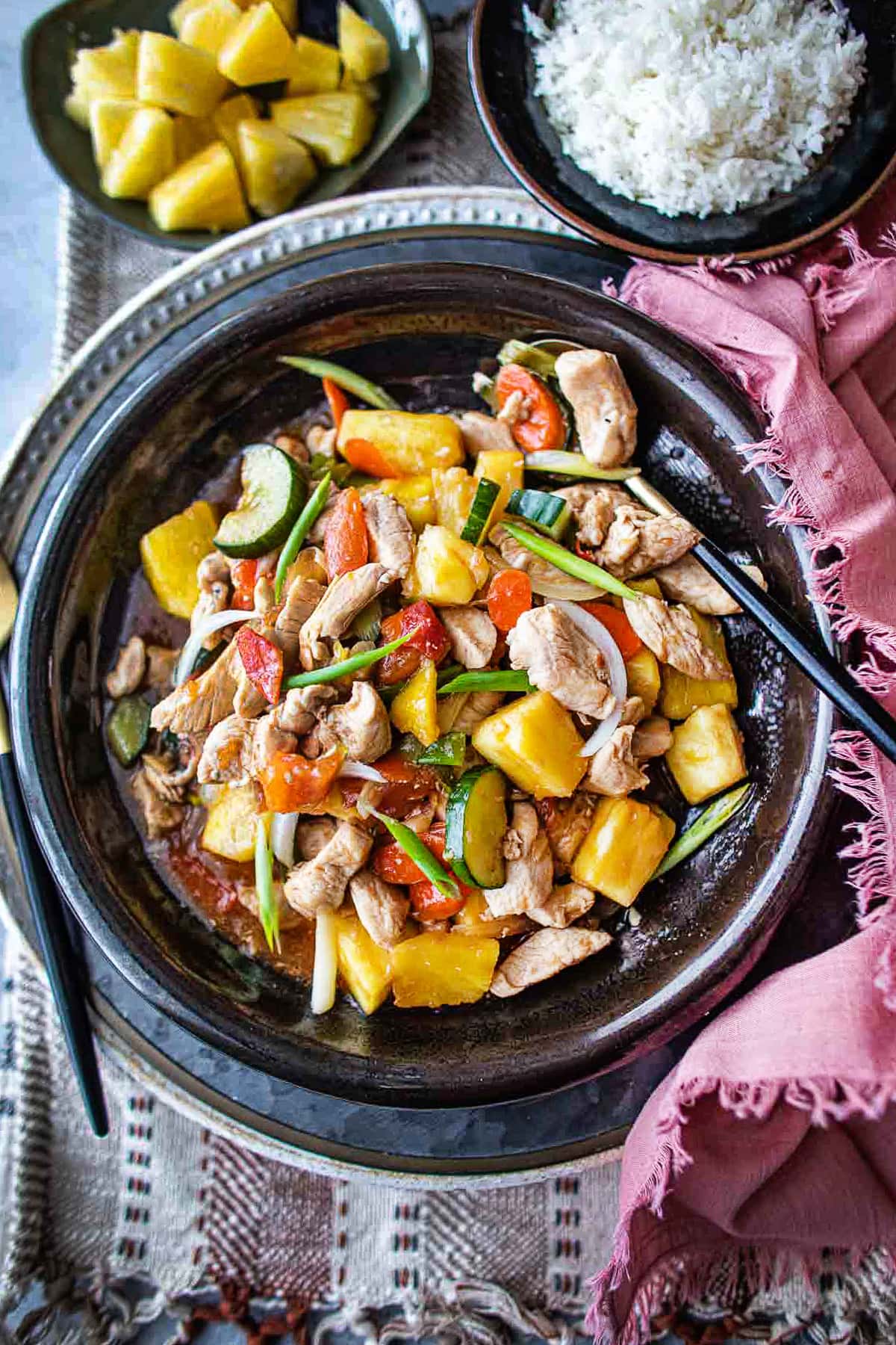 Sweet and sour pineapple stir fry with chicken on a plate with fork.