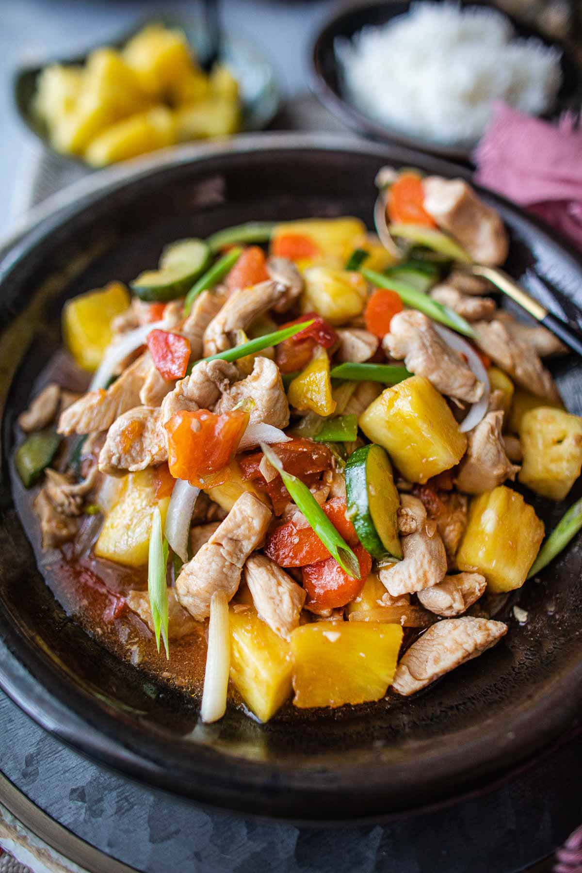 Thai sweet and sour stir fry chicken and pineapple on a plate on the table.