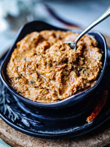 TOm yum paste in a bowl on the table with a spoon.