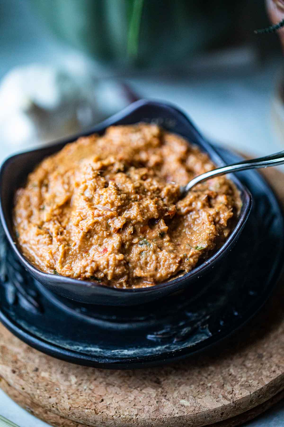 Tom yum paste in a black bowl on the table.