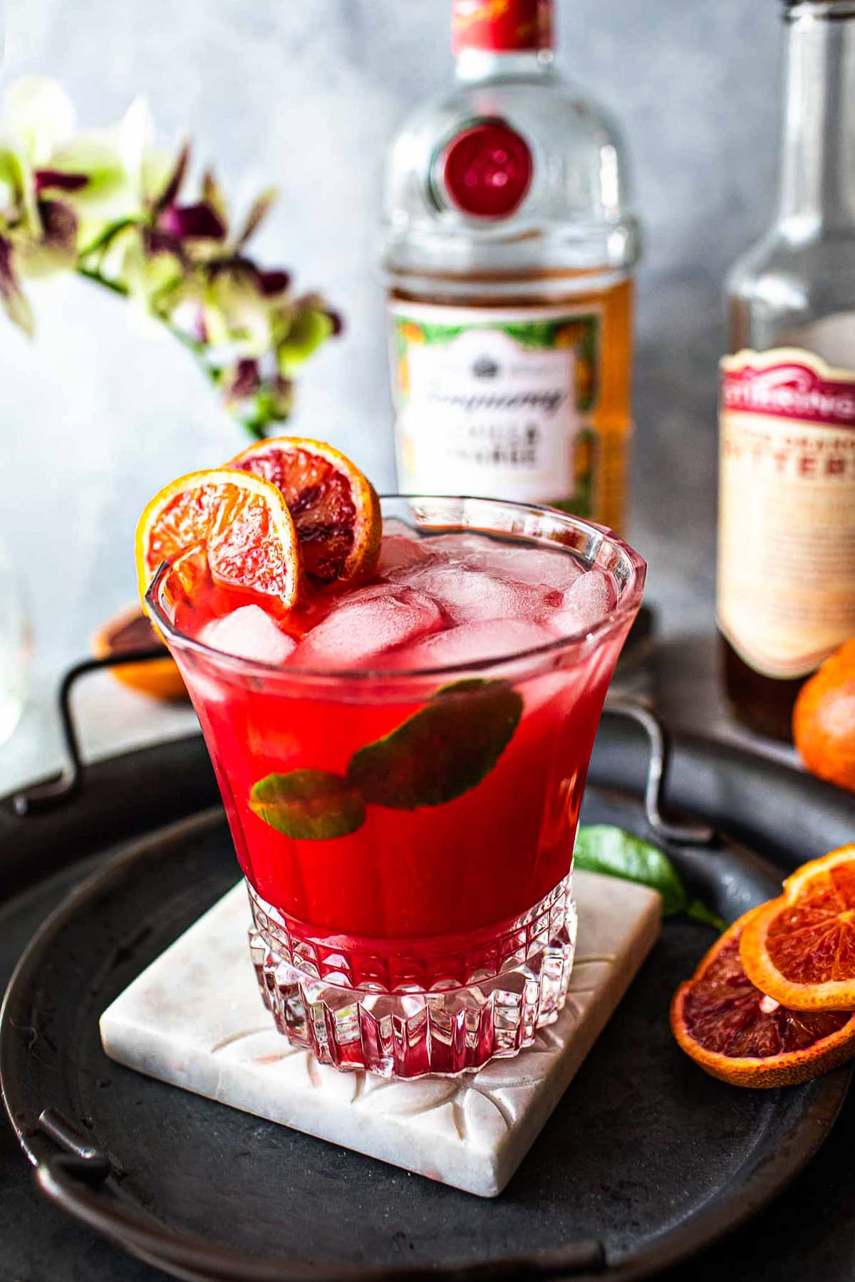 Tanqueray Sevilla orange cocktail on a tray on the table.
