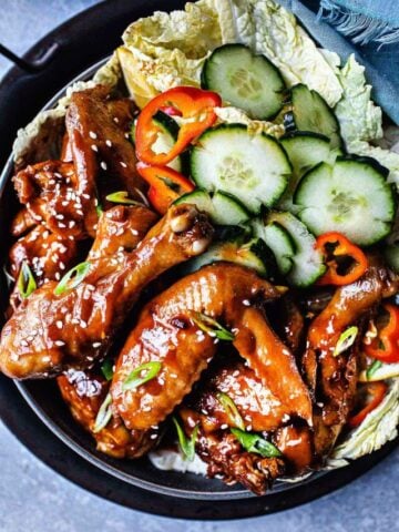 Sticky wings with sriracha sauce with cucumber slices.