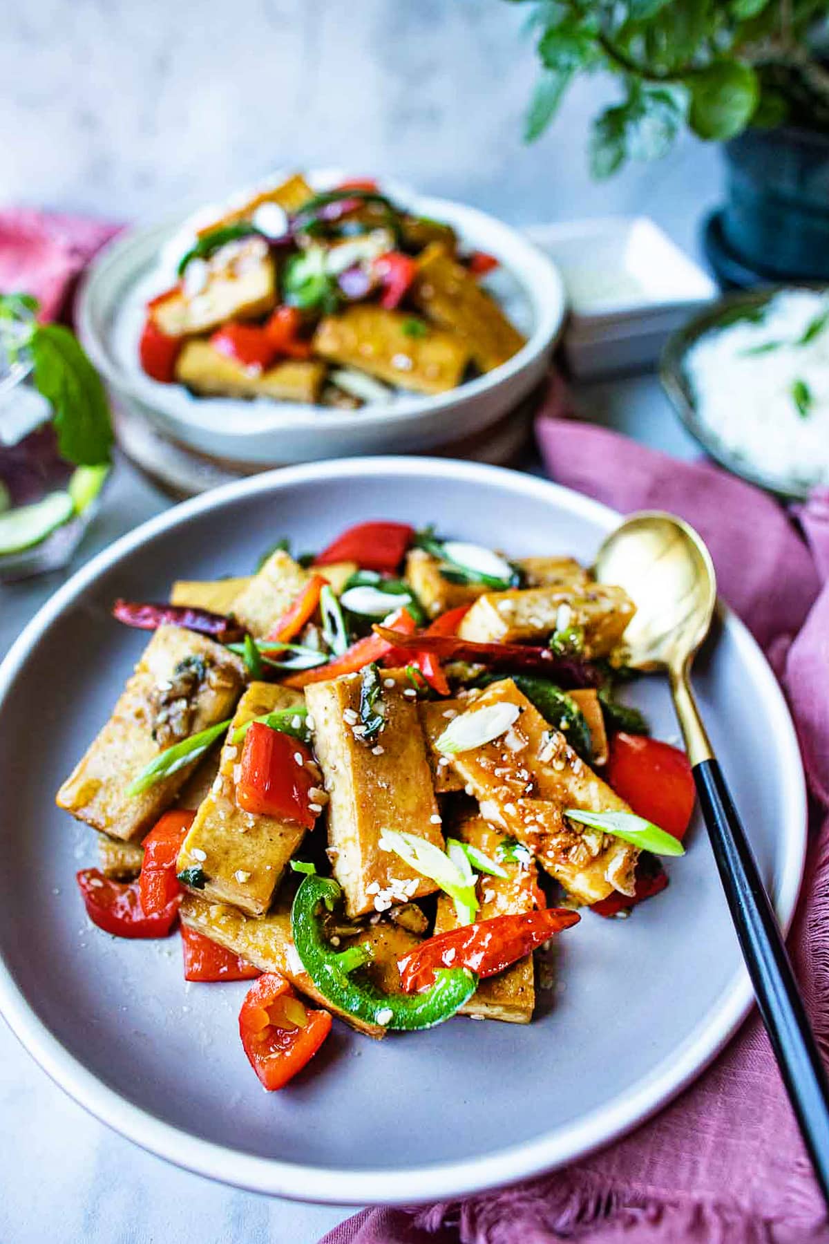 Thai garlic tofu on a plate with a spoon on the side. 