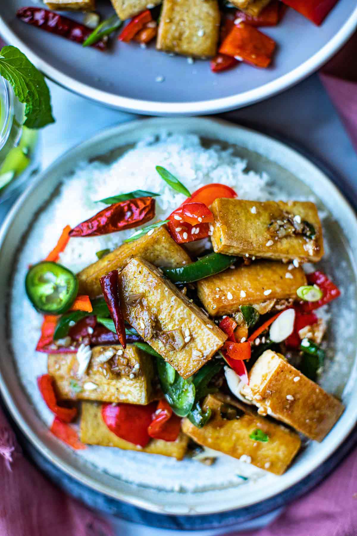 Thai garlic pepper tofu over rice on a plate.