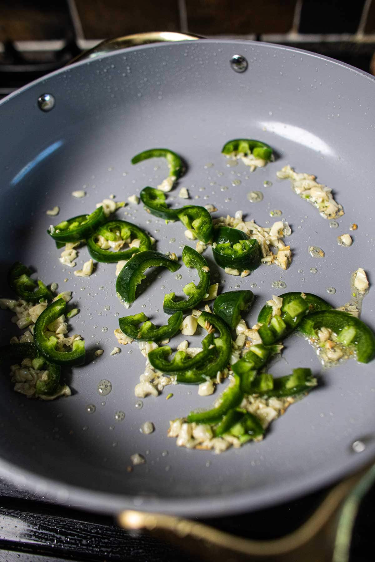 Garlic and green peppers sautéed in a pan. 