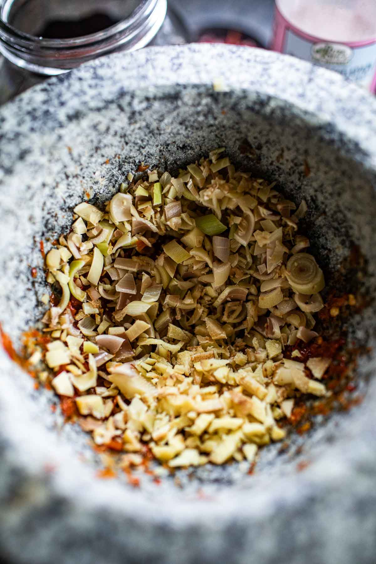 Lemongrass and galangal in tom yum paste in a mortar.