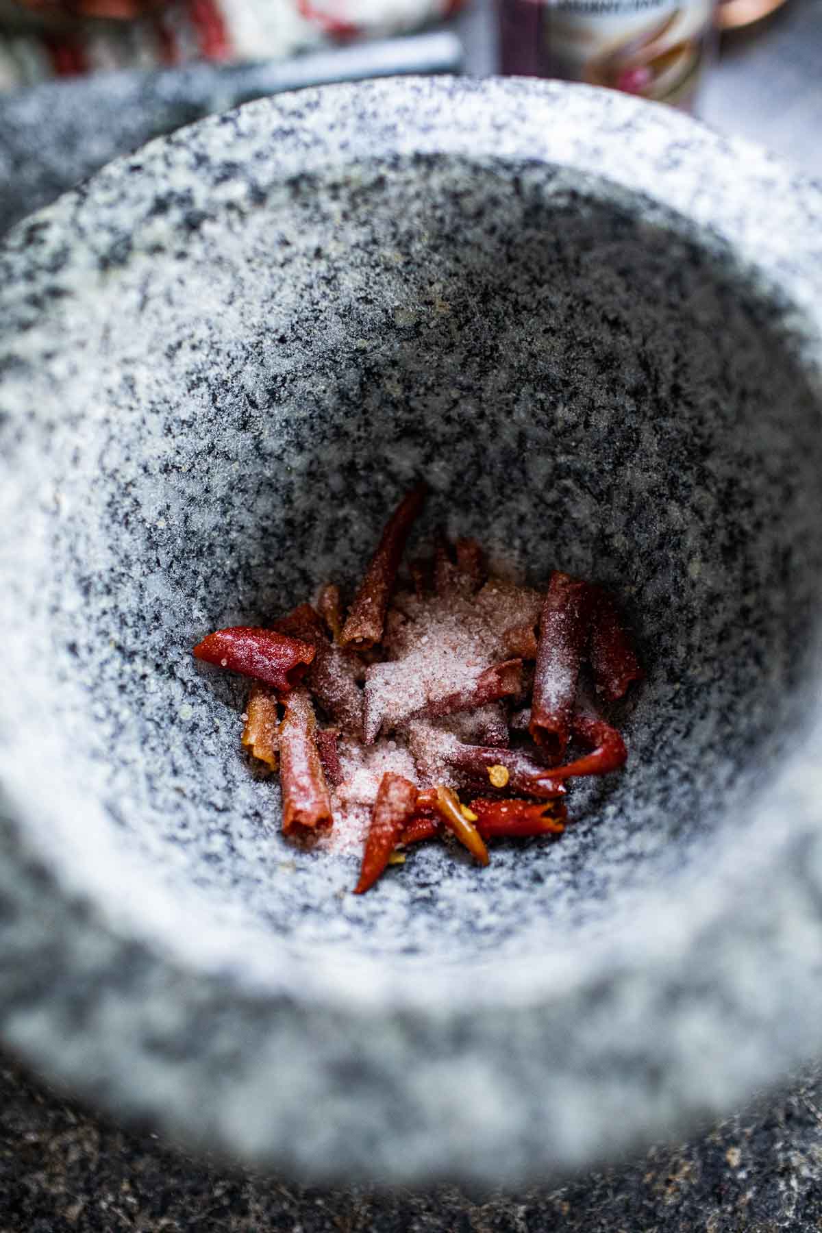 Red chilis and salt in a mortar.