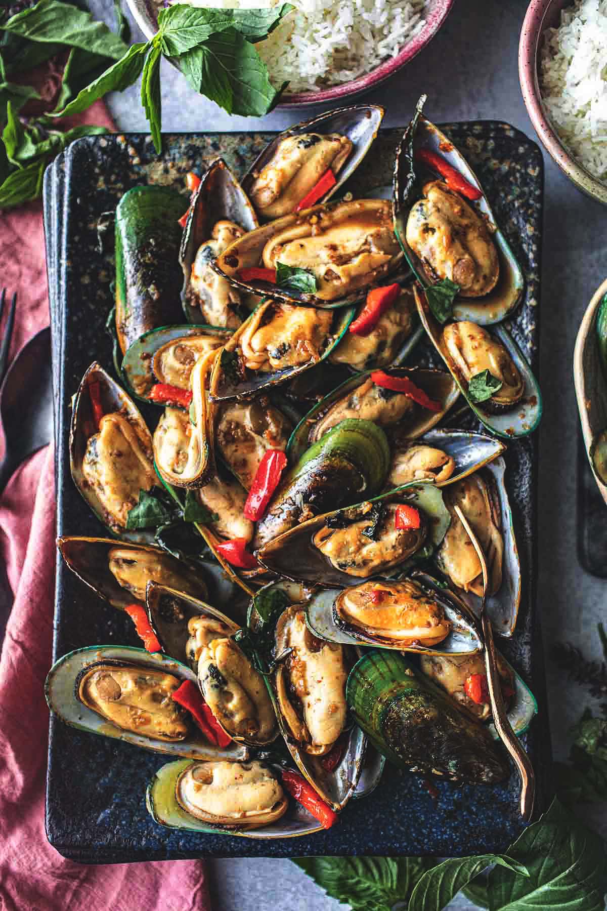 Mussels stir fry with chili paste on a platter on the table. 