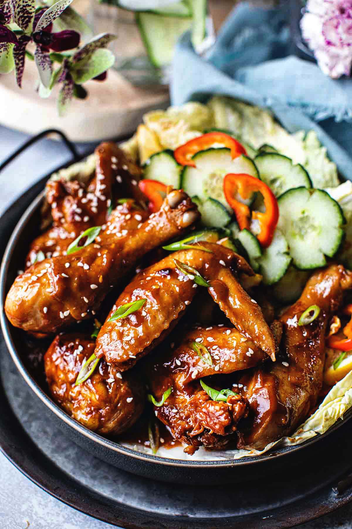 spicy wings on a platter with cucumber slices.