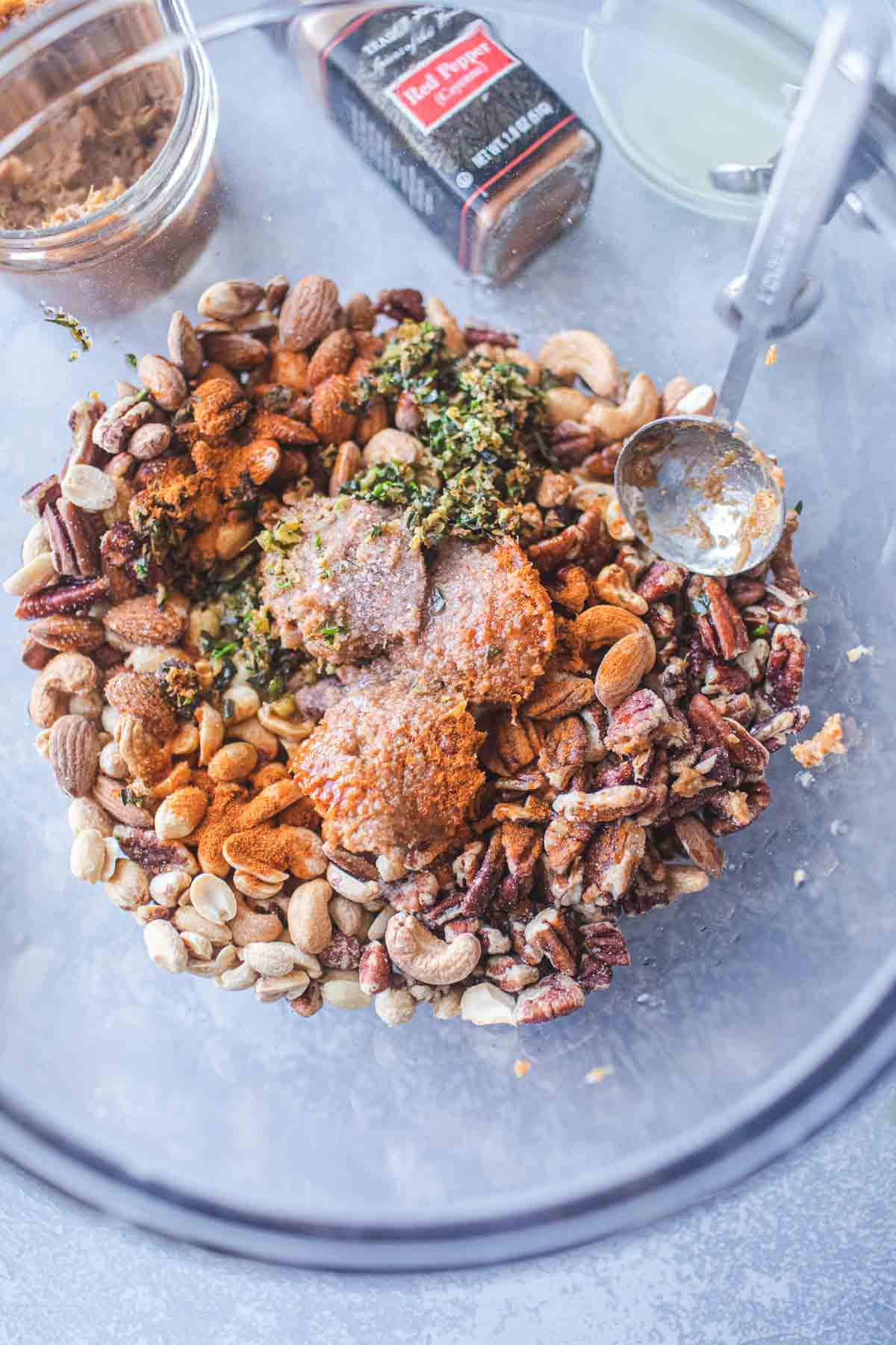 Tom yum roasted mixed nuts in a glass bowl on the table.