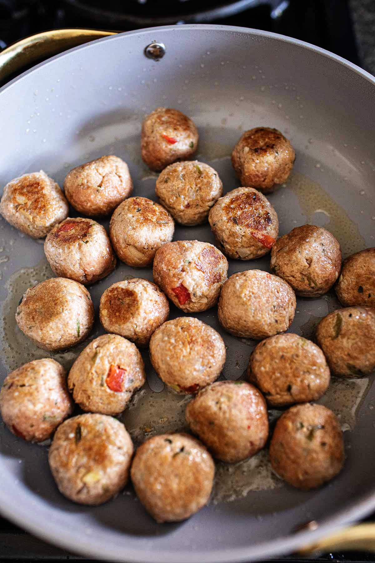 Tom Yum Meatballs frying in a pan.