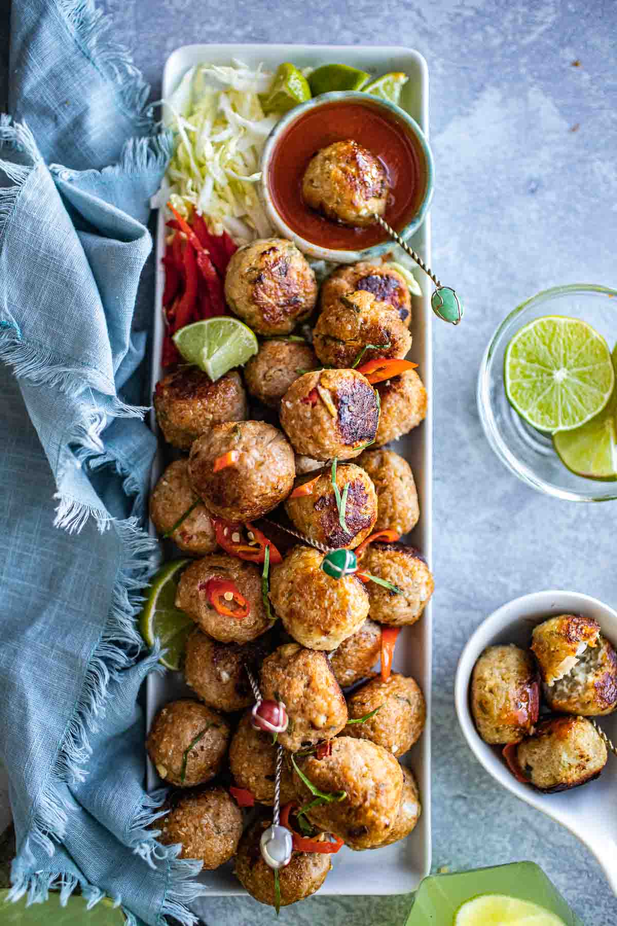 Hand holding Thai tom yum meatball on a stick.