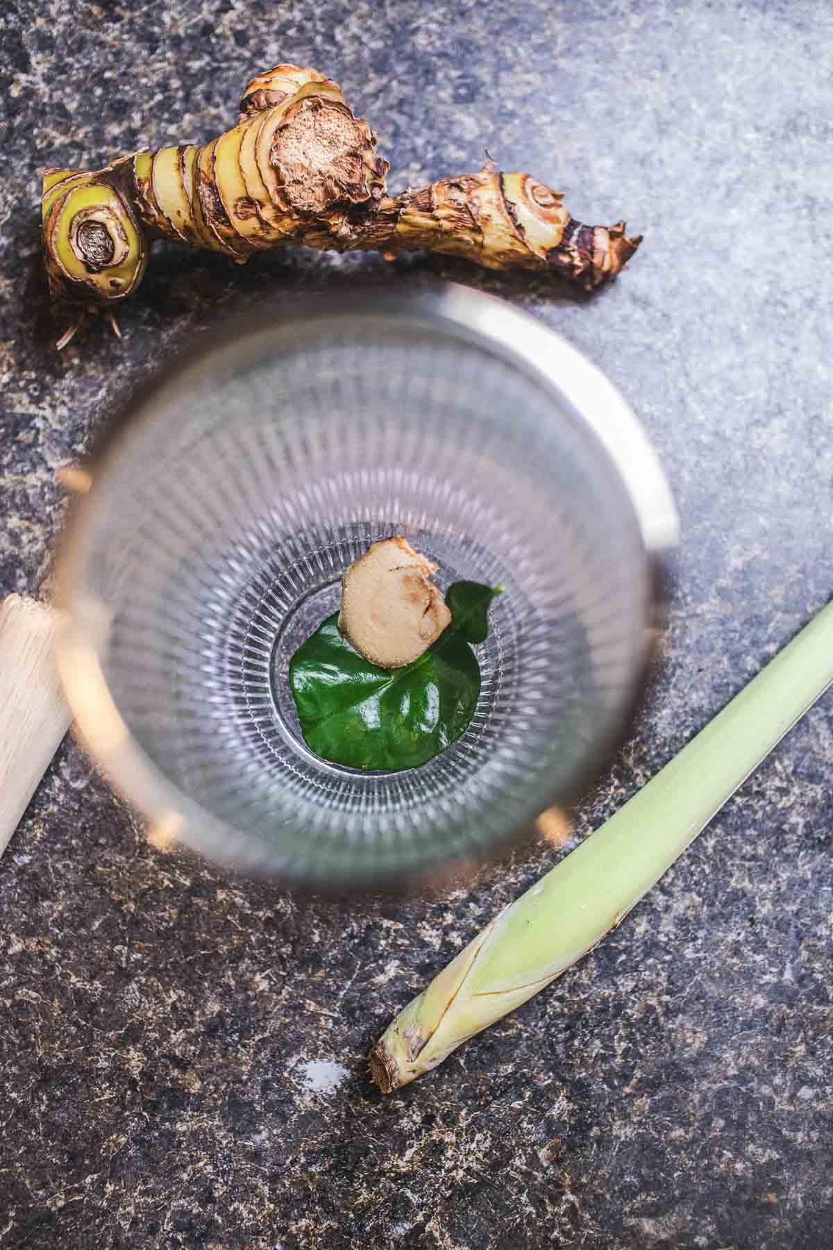 Kaffir lime leaf and galangal in a shaker.