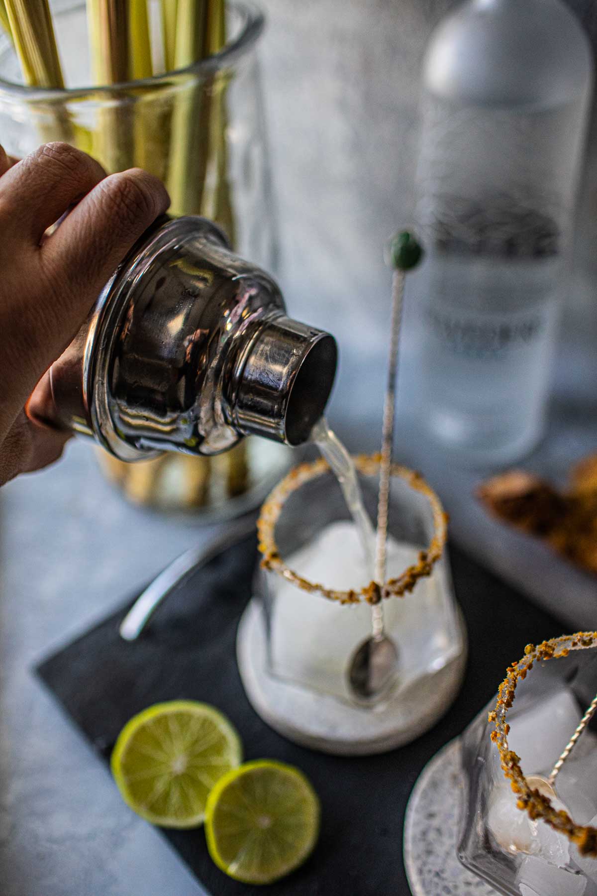 Pouring Tom Yum cocktail from a shaker.