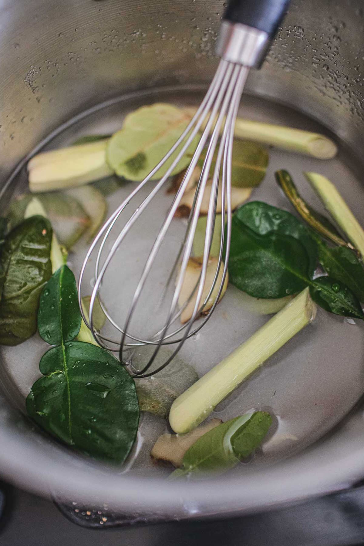 Fresh herbs simple syrup in a stock pot. 