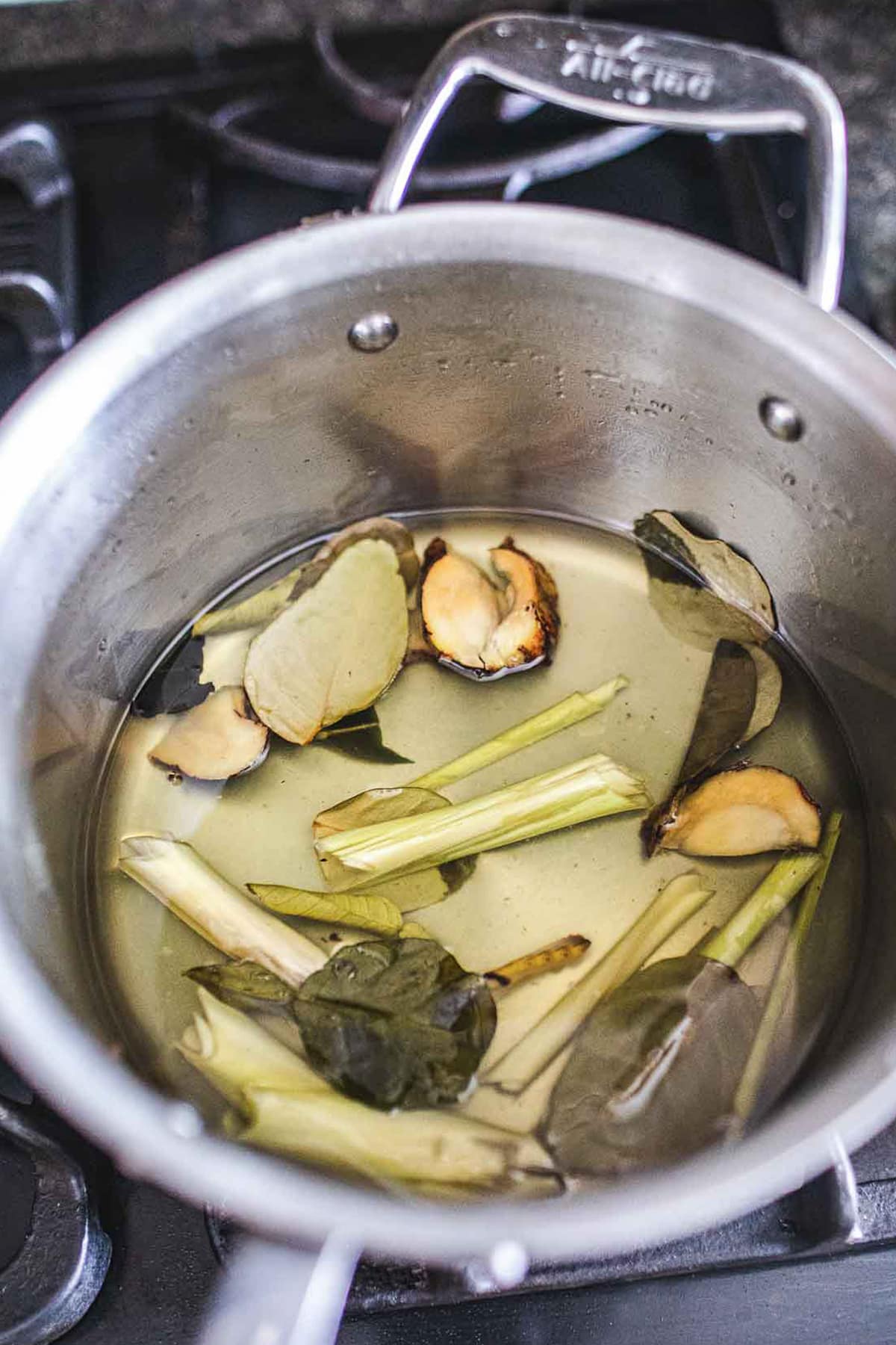 Fresh herbs simple syrup in a stock pot on the stove. 