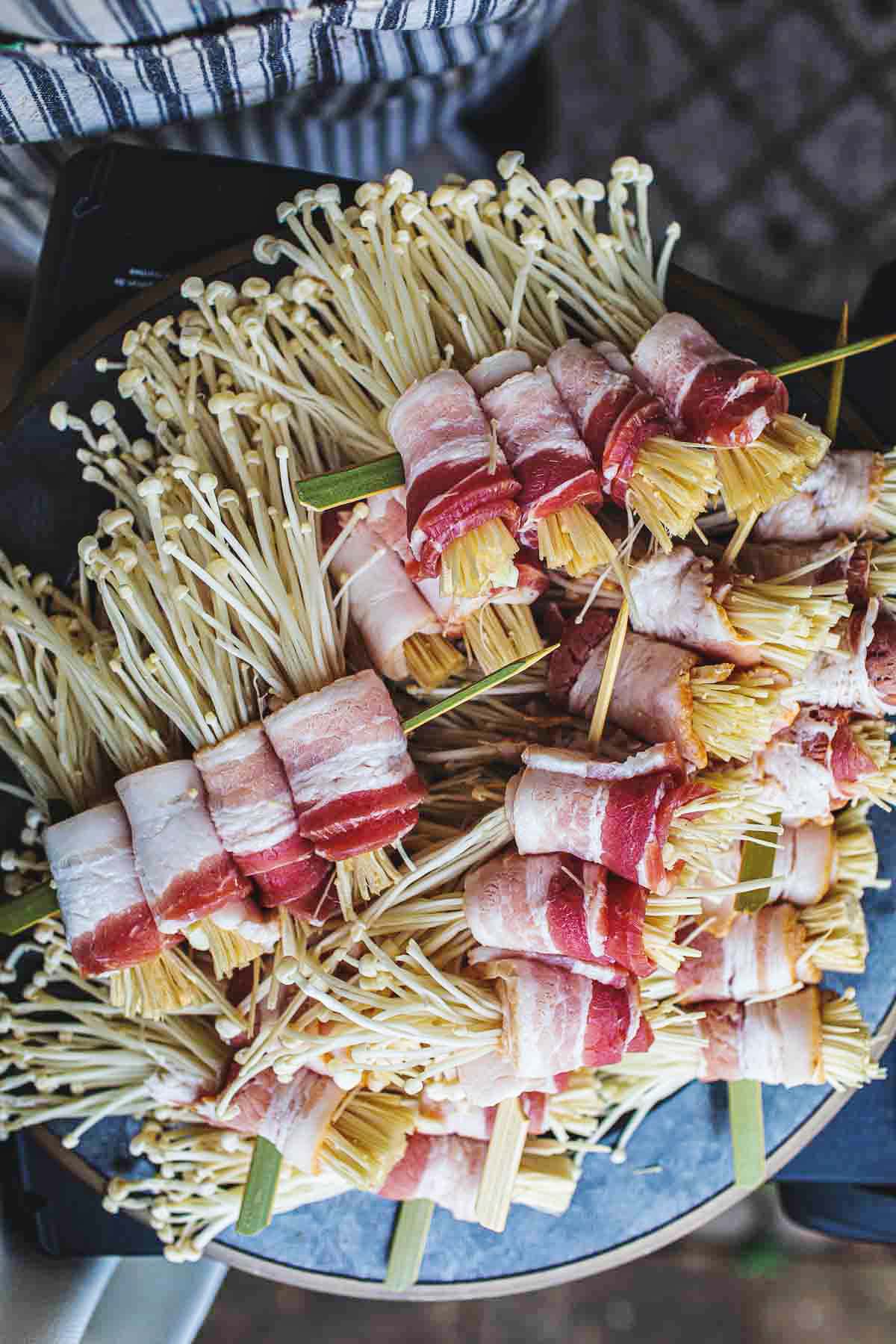 Enoki and bacon skewers on a platter. 