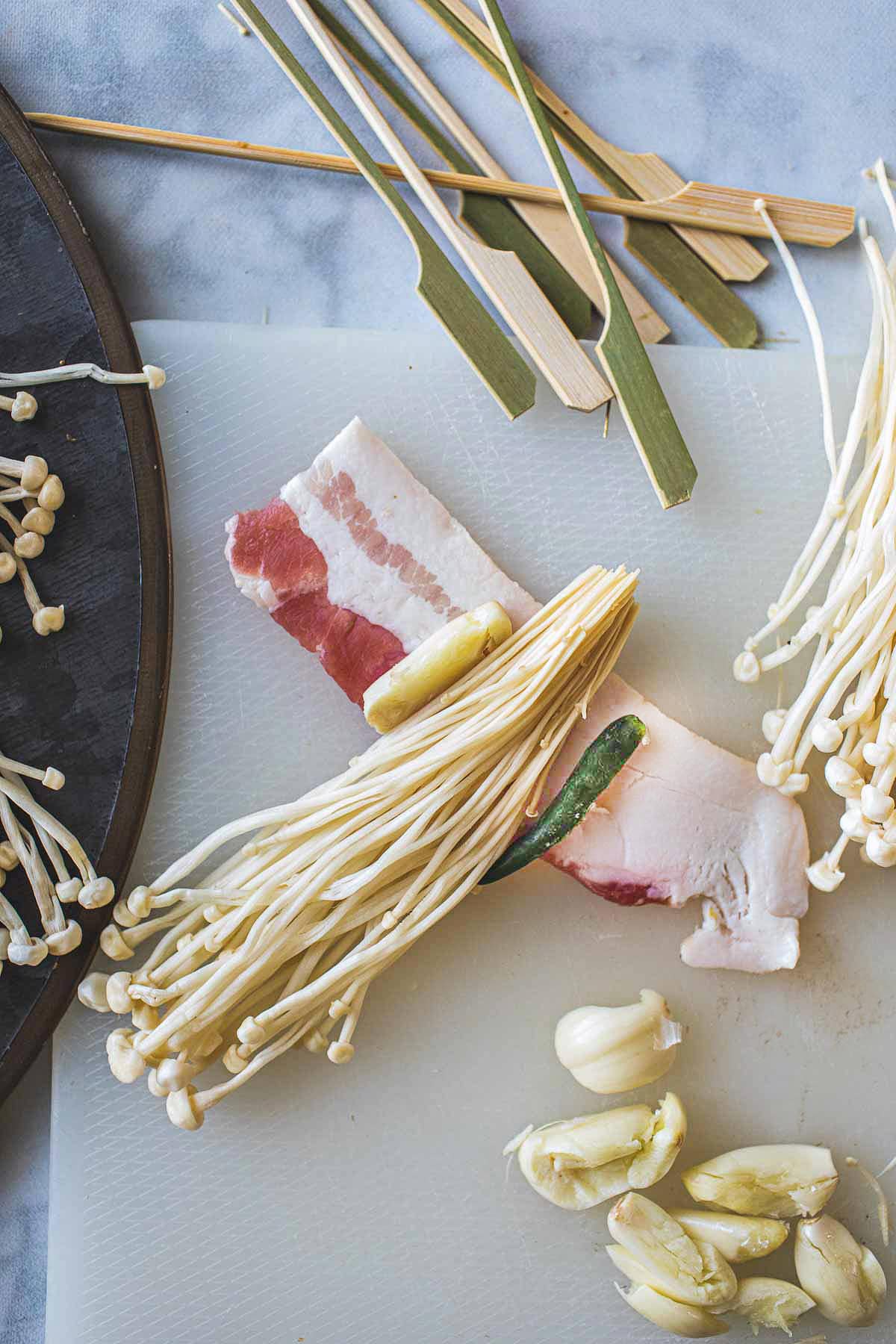 Enoki bacon with bacon and chili and garlic on a table. 