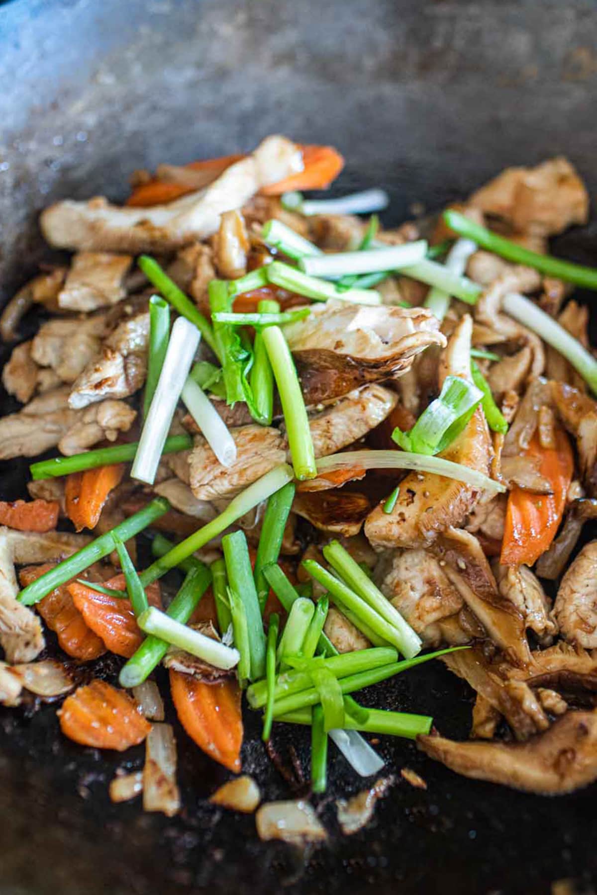 Thai chicken with ginger and mushrooms in a wok.