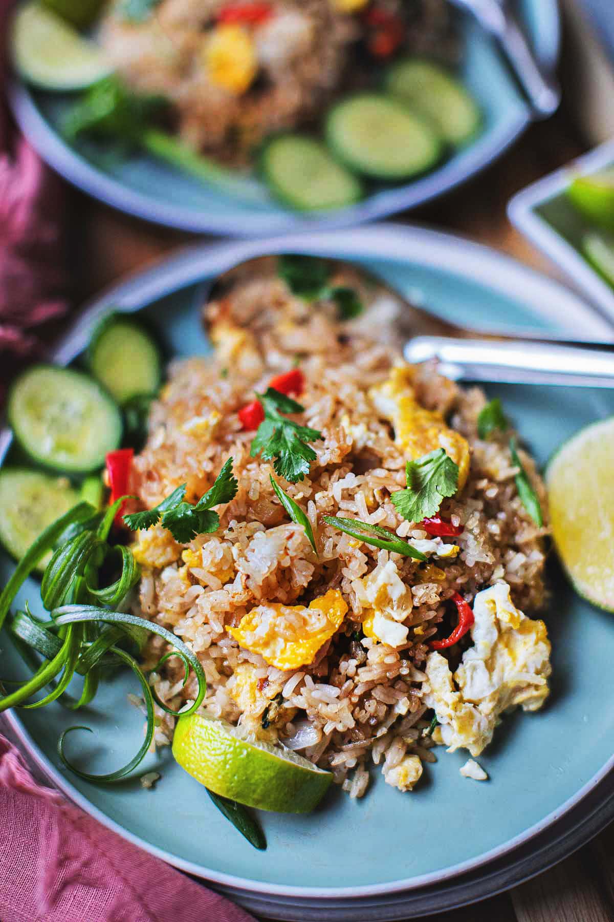 Thai fried rice on a plate with garnishes.