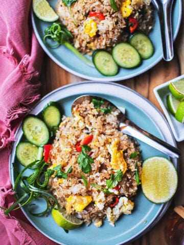 Thai Khao Pad on 2 plates with garnishes.
