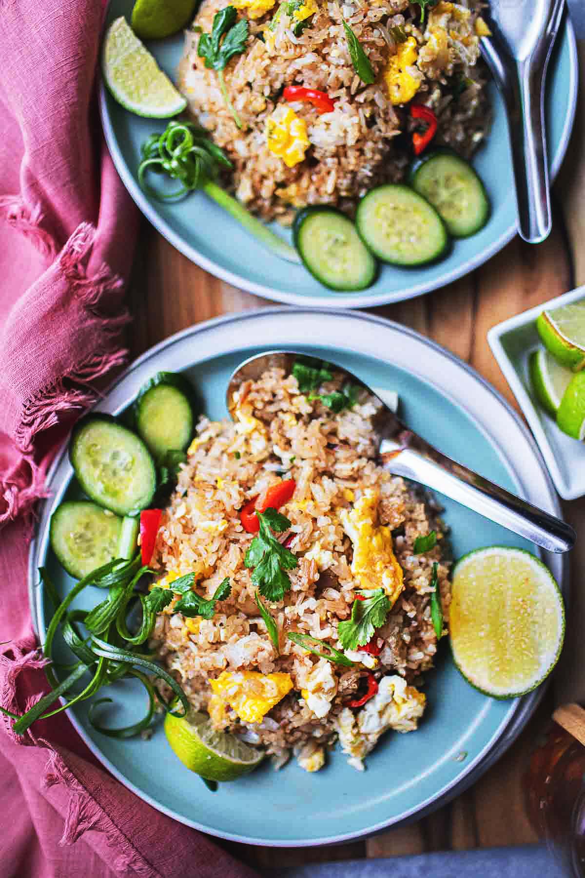 Thai Khao Pad on 2 plates with garnishes.