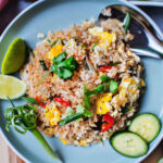 Thai vegetarian fried rice on a plate with cucumber slices.