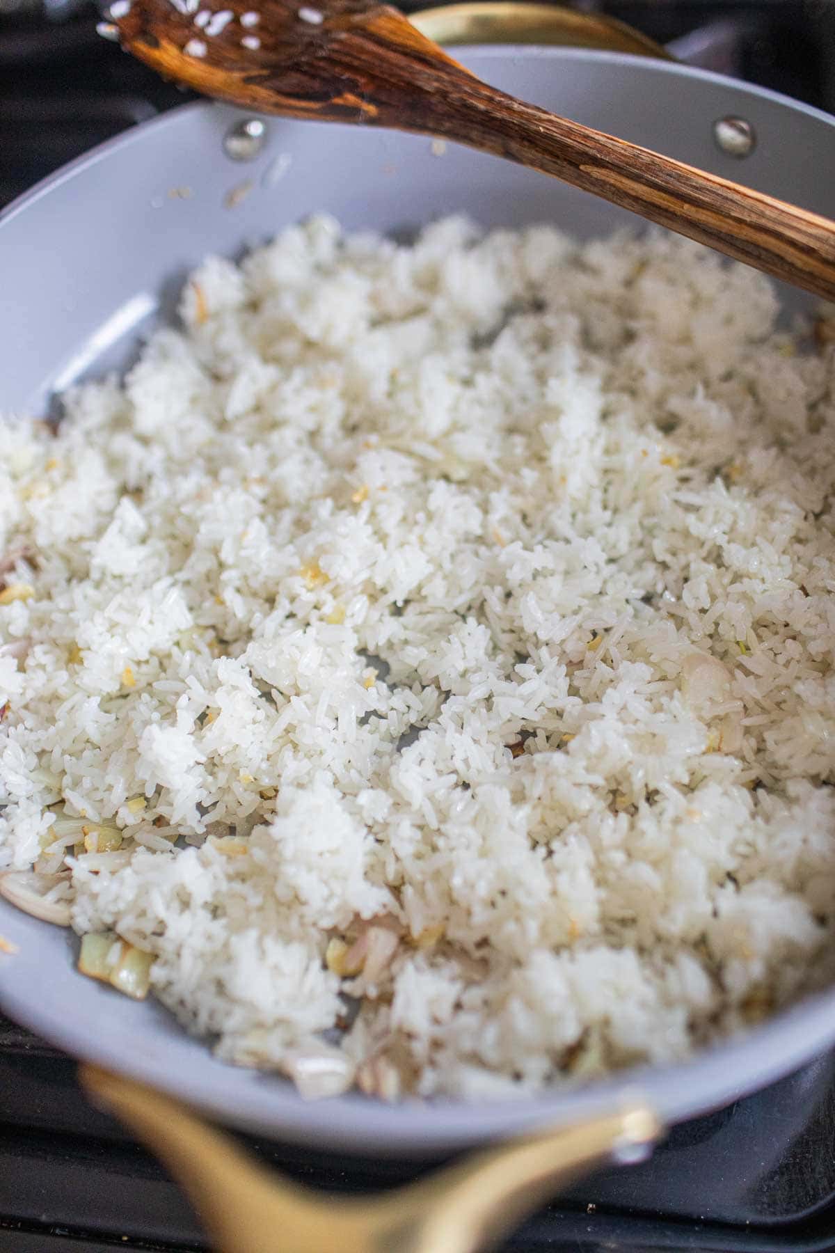 Rice on a pan with garlic and onion.